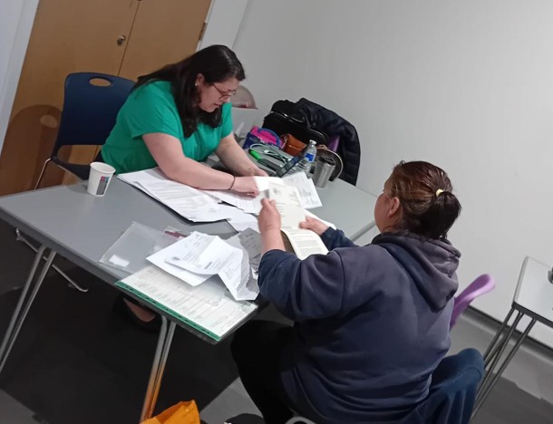 Two women looking at paperwork across a desk