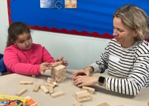 Lady with young girl playing with Jenga blocks