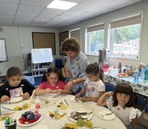 woman assisting children with craft projects